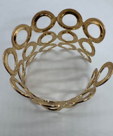 Gold-plated cuff bracelet featuring a distinctive open mesh or "honeycomb" design made of interconnected circular or oval rings